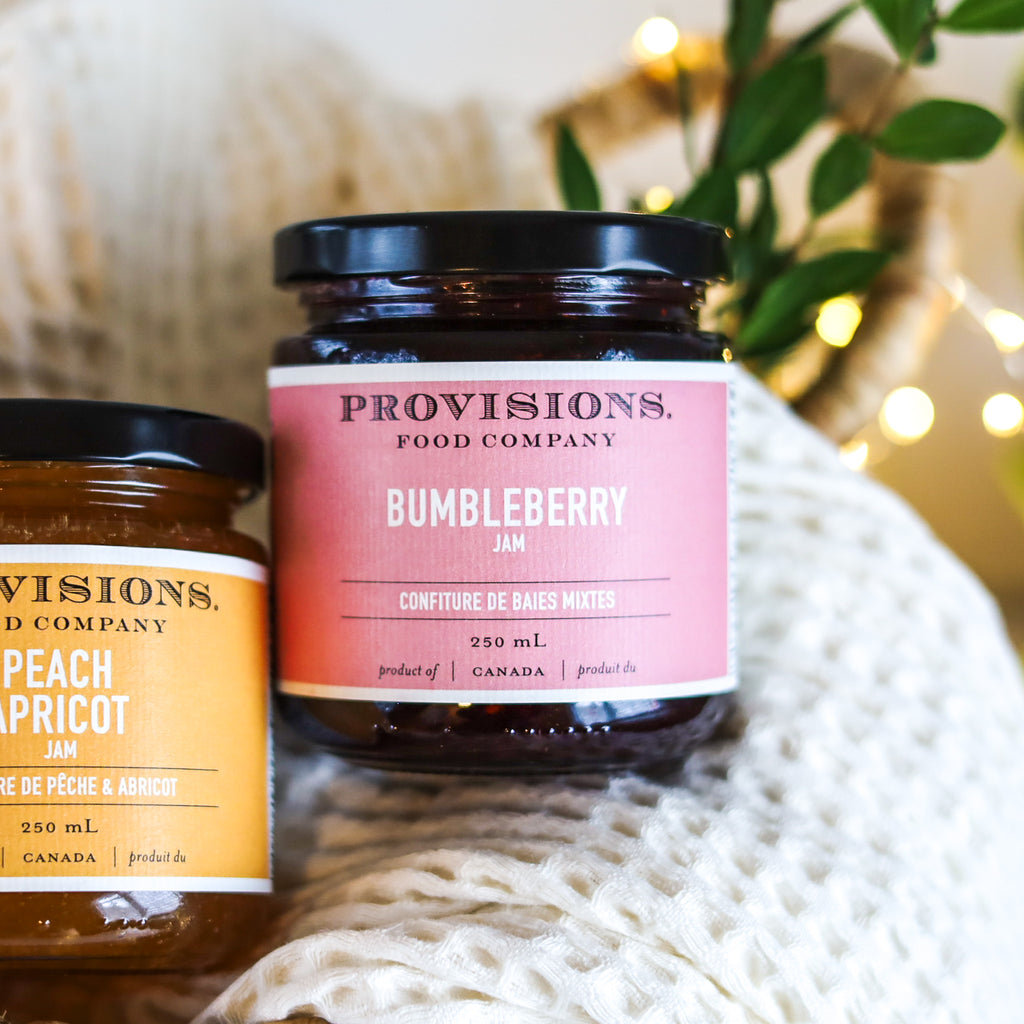 A Jar of Provisions Food Company Bumbleberry Jam sitting in a gift basket