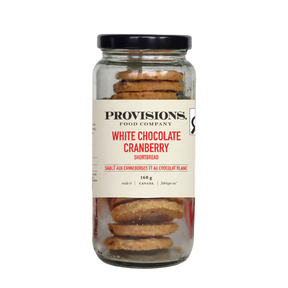 A glass jar of Provisions Food Company White Chocolate Cranberry Shortbread with a black lid and cream-colored label, set against a plain white background.
