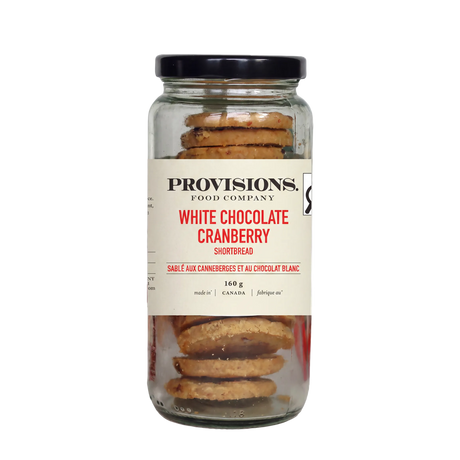 A glass jar of Provisions Food Company White Chocolate Cranberry Shortbread with a black lid and cream-colored label, set against a plain white background.